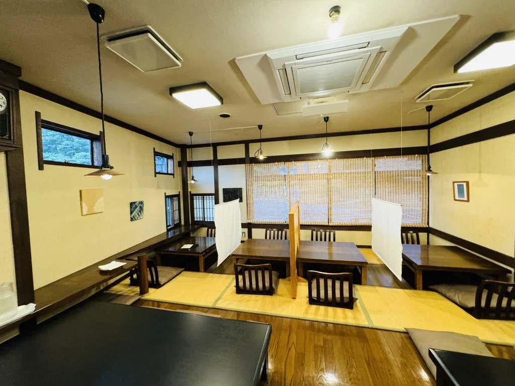 Floor-level seating inside Shuzenji no Yoshokuya, with a cozy recessed table setup on wooden flooring