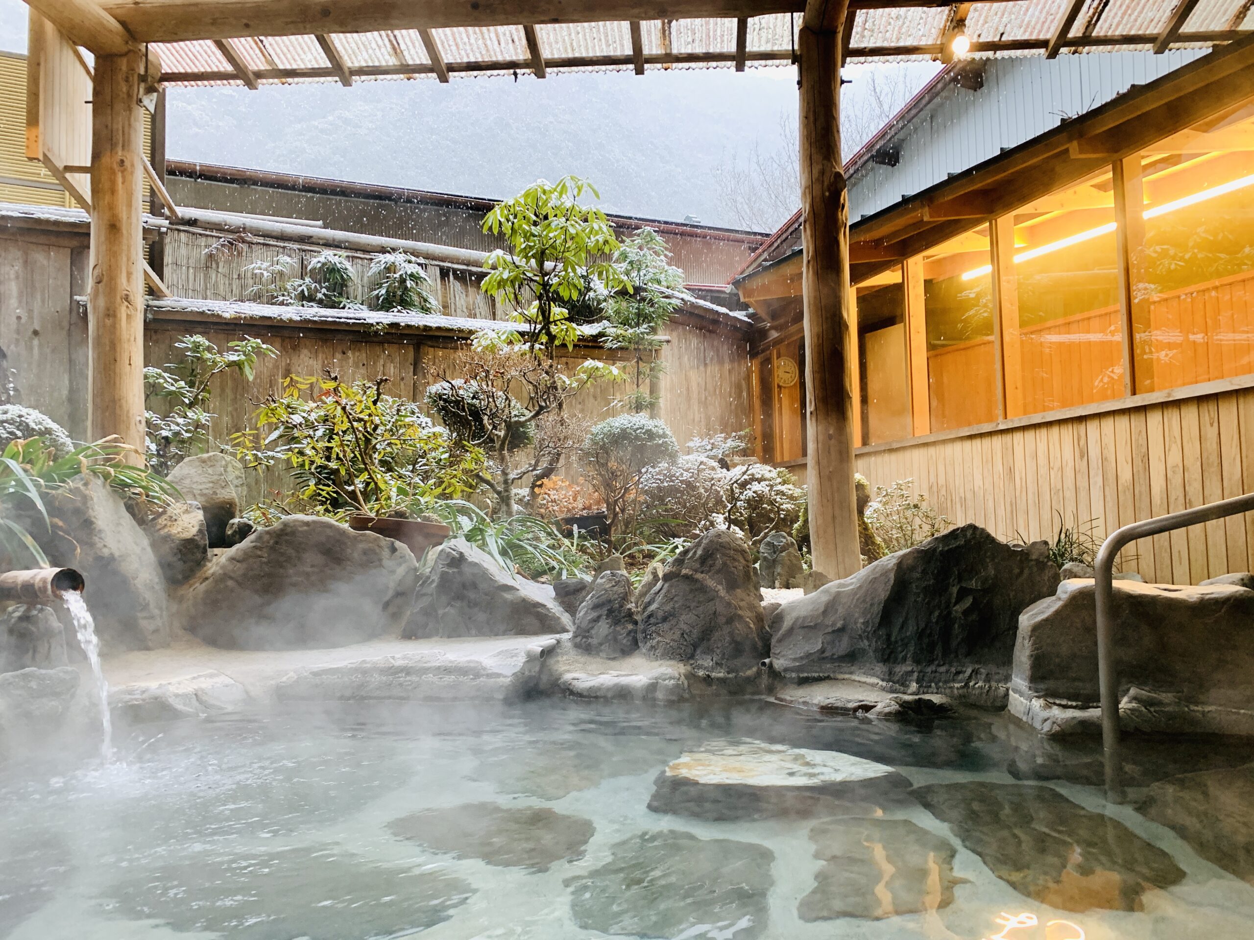 Private open-air bath "Hana-no-Yu" at Ohnogiso Ryokan with snow gently falling