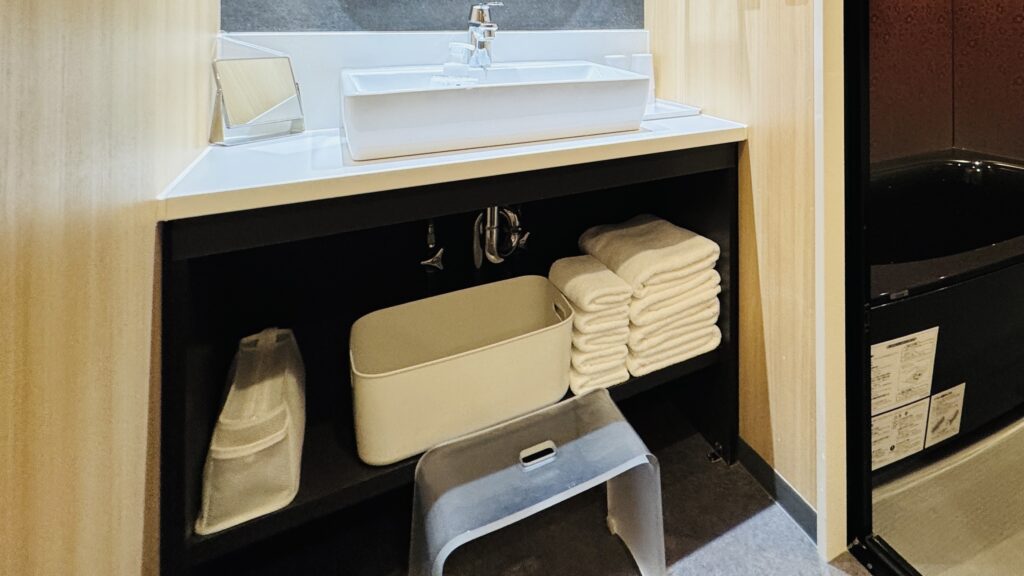 Bathroom sink area in the Pokémon Room with a step stool provided for young children.