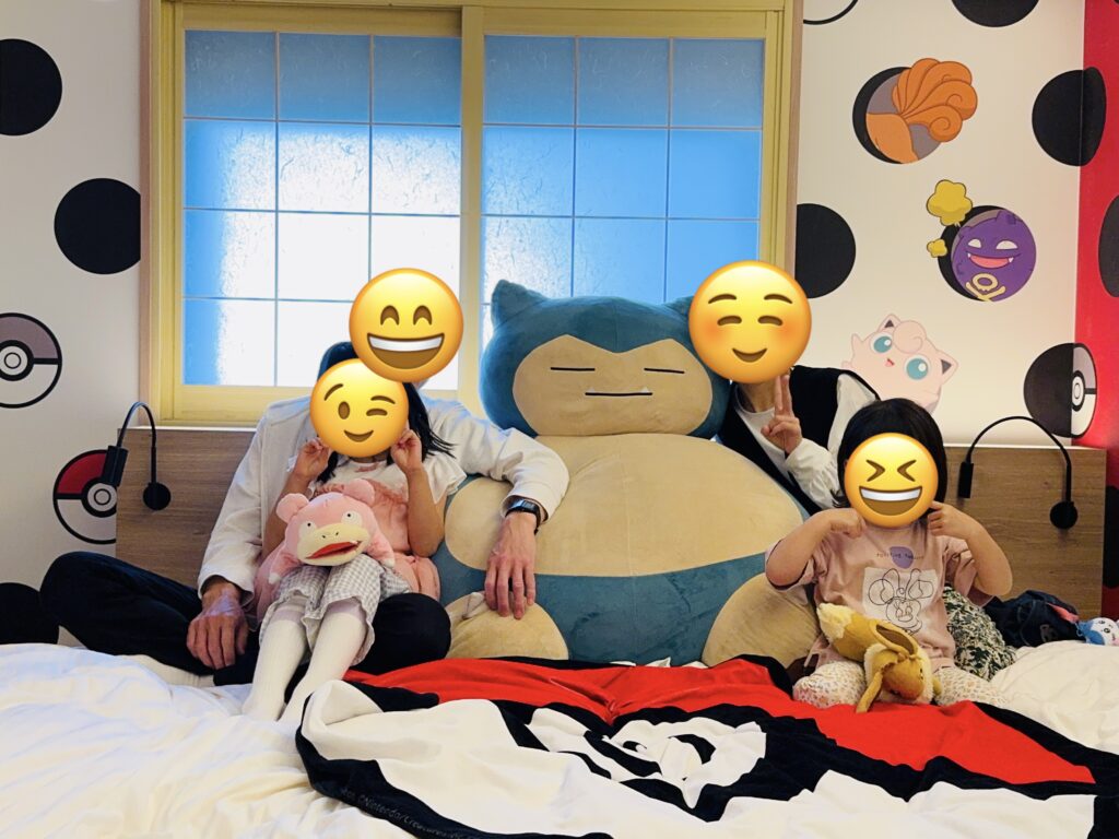 Guests posing for a photo with the iconic giant Snorlax plush inside the Pokémon Room.