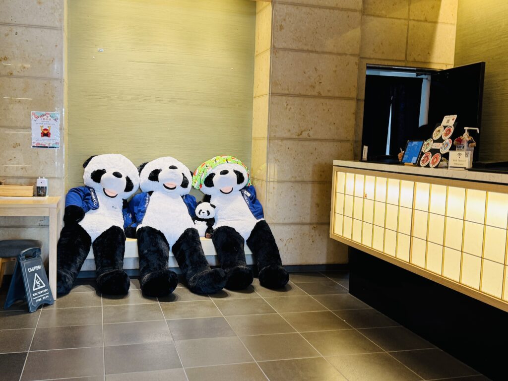 Front desk area at MIMARU TOKYO UENO EAST, featuring a cute panda plush on display.