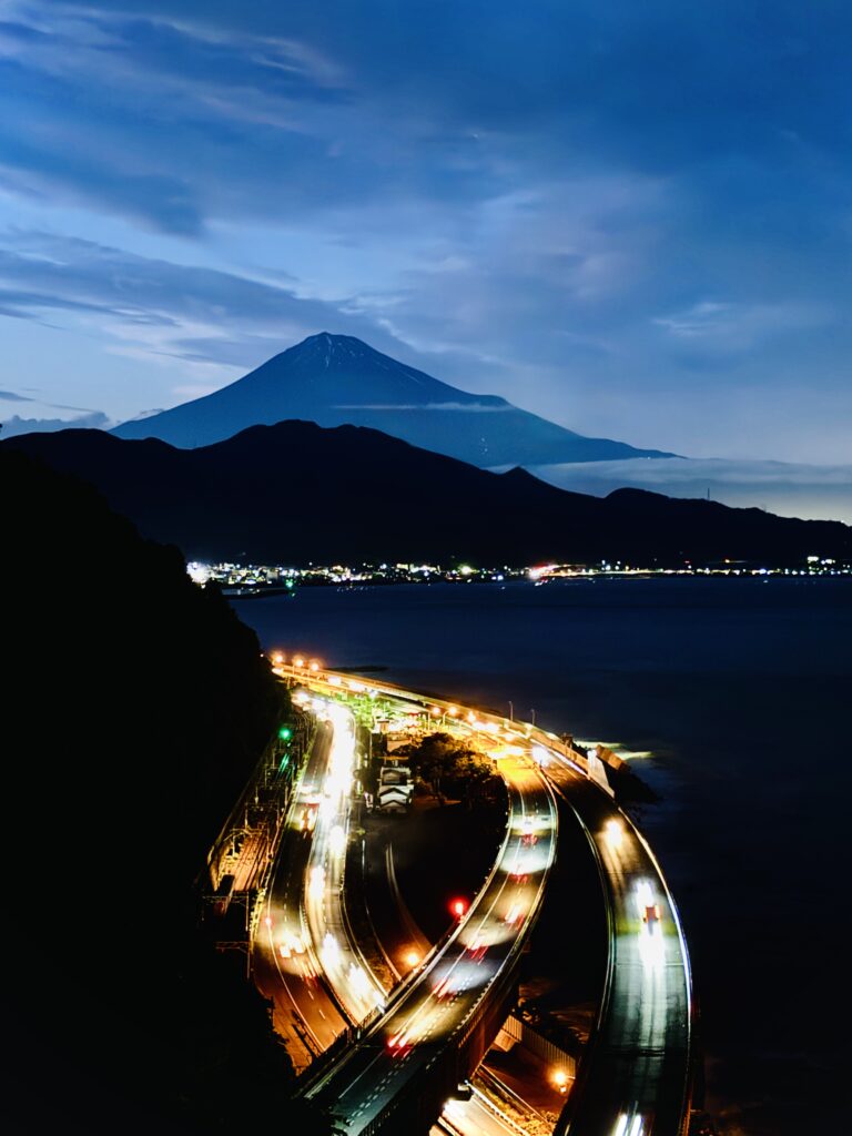 Evening view of Mt. Fuji from the Satta Pass observation deck with highway lights below