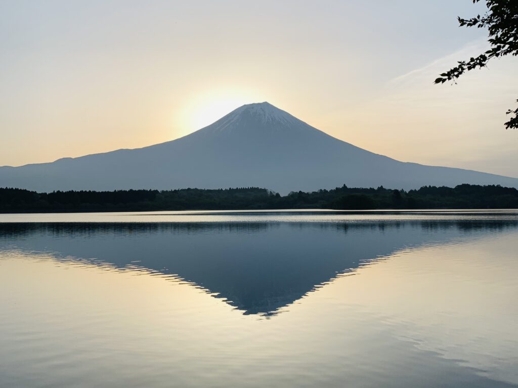 Mt. Fuji just before sunrise, reflected on the still surface of Lake Tanuki in the quiet early morning.