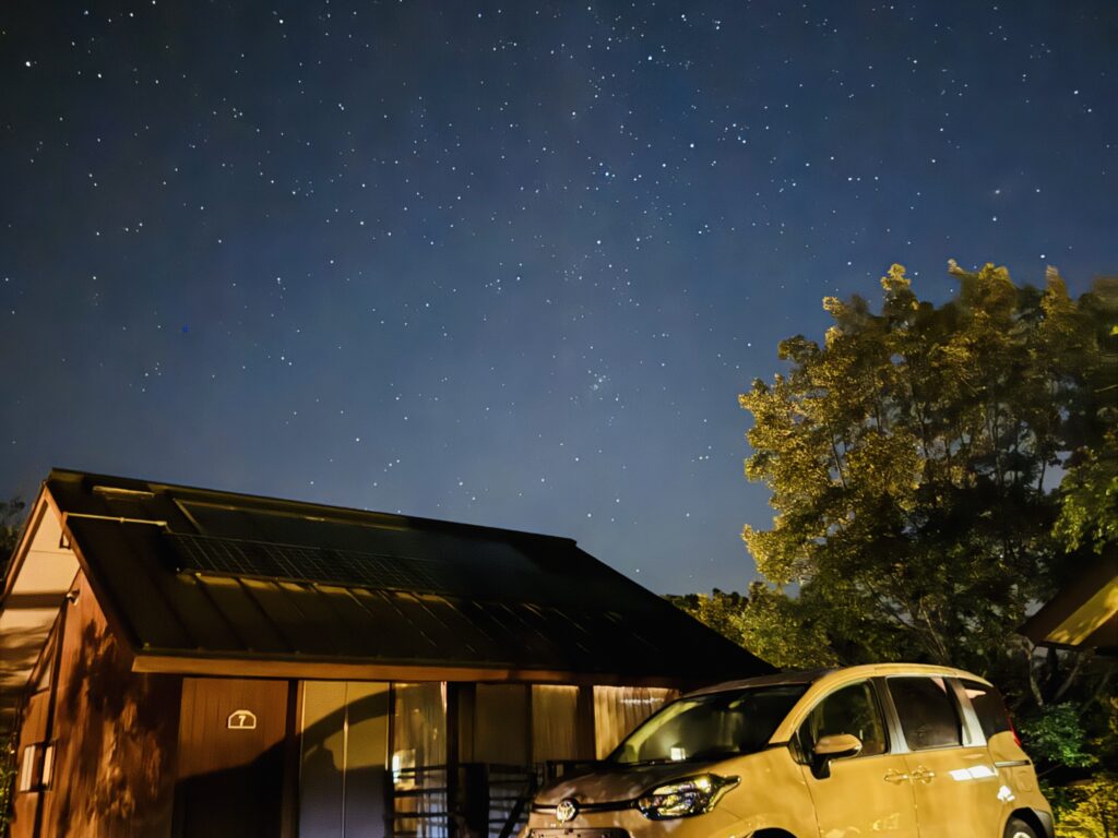 Star-filled sky above the cottages of Kyukamura Fuji, with minimal light pollution allowing for a stunning view of the night sky.