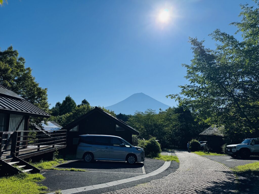 Mt. Fuji seen from the cottage area of Kyukamura Fuji, with a peaceful atmosphere and open view of the lake and mountain.