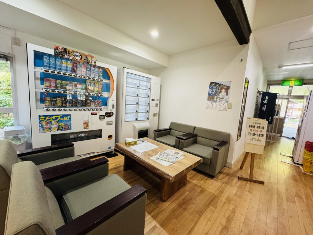 Lobby area near the front desk at Yamabiko-so Inn in Nishi-Izu, with sofas and vending machines