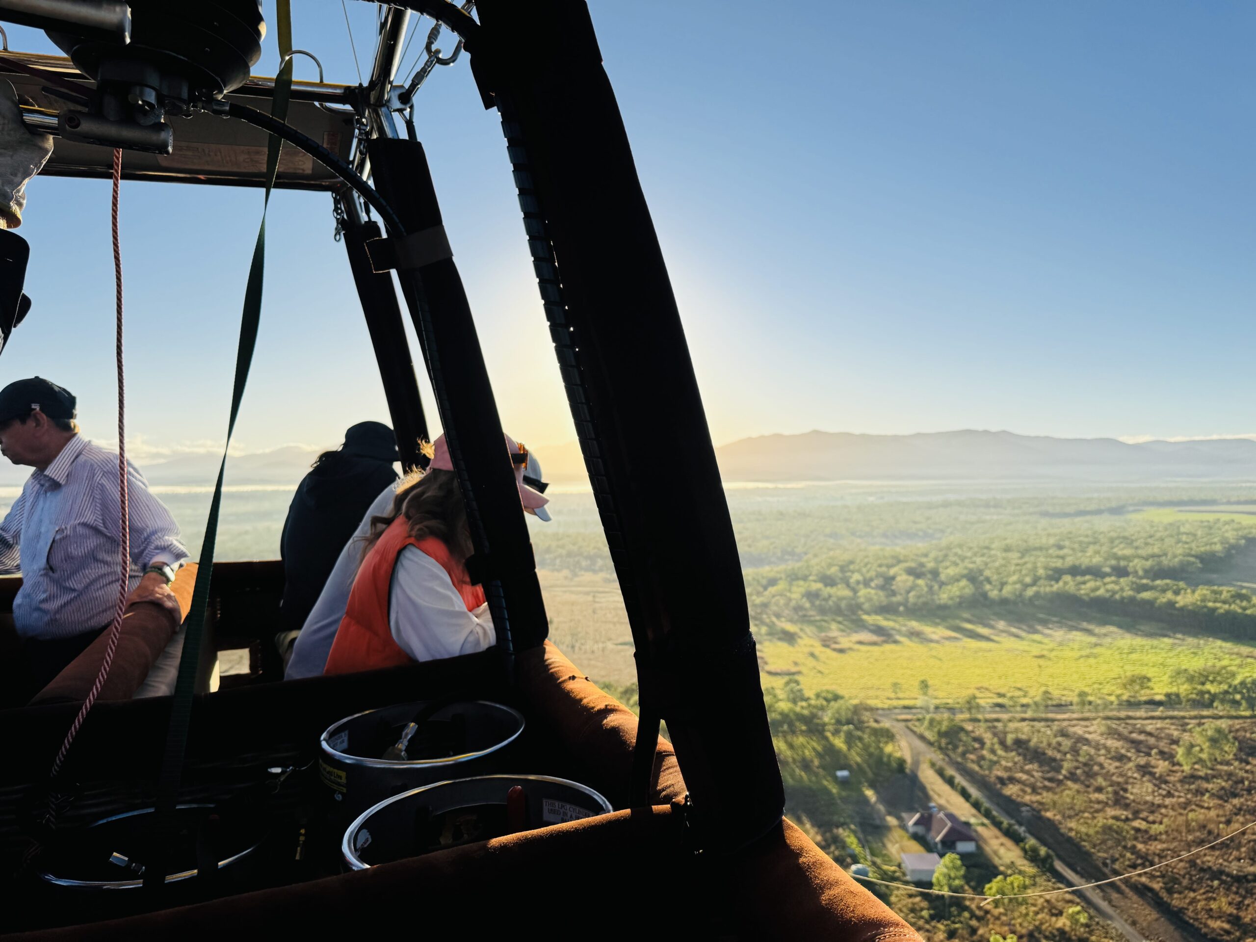 離陸したばかりの熱気球から眺めるケアンズ・マリーバ高原の風景。静寂の中、気球がゆっくりと上昇していく様子。