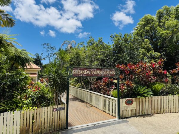 Entrance gates of the Kuranda Scenic Railway Station, with the Skyrail terminal nearby at the village entrance.