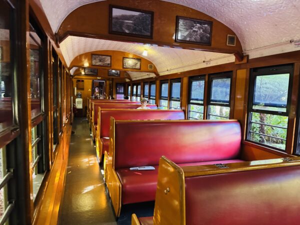 Interior of the Kuranda Scenic Railway’s standard carriage with classic wooden seats; a separate Gold Class carriage is also available.