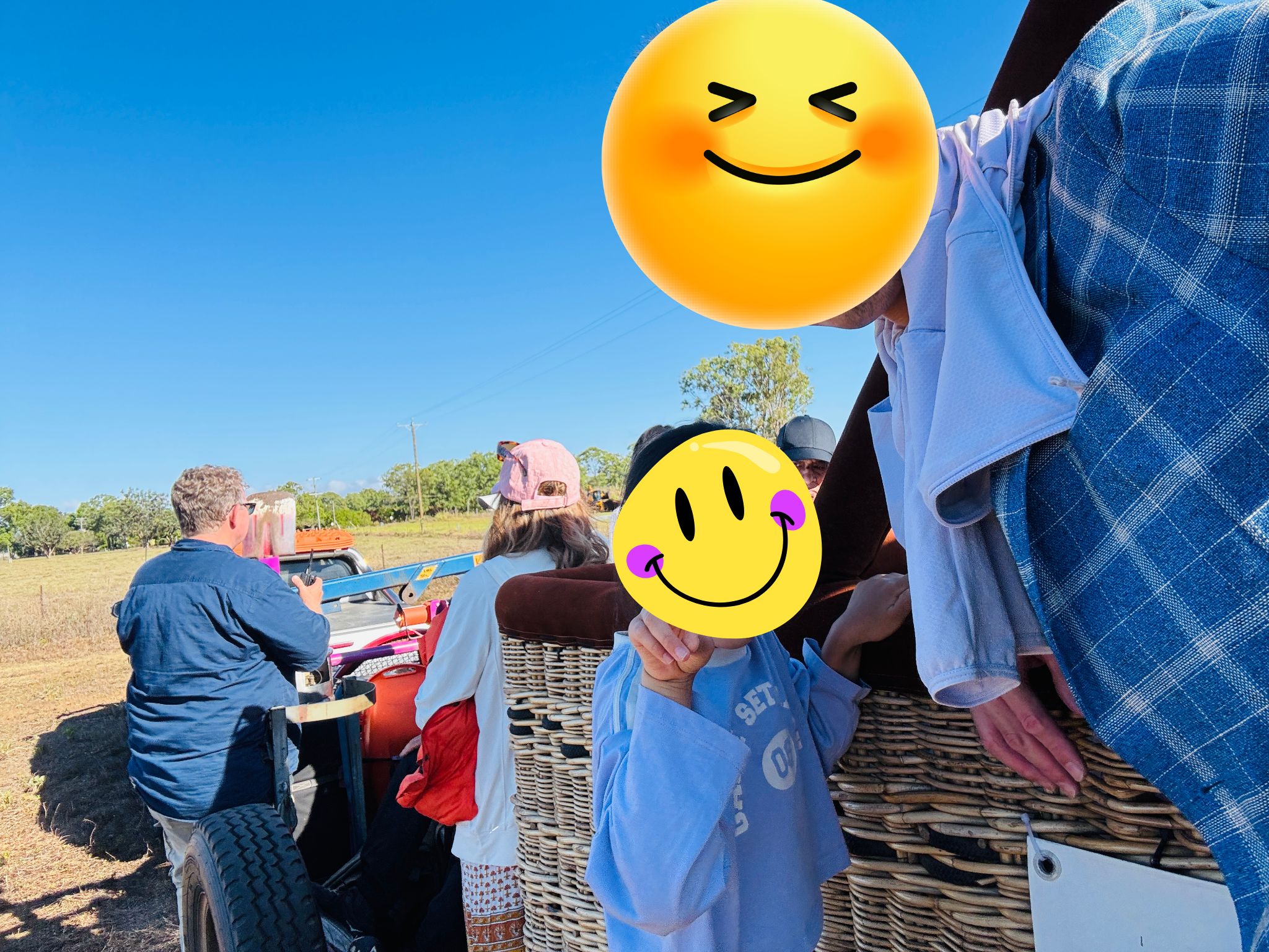 熱気球の撤収作業を終えた後、たたまれた気球を積んだ牽引車の荷台に参加者が乗り込み、送迎バスの待つ場所へ向かっている様子。